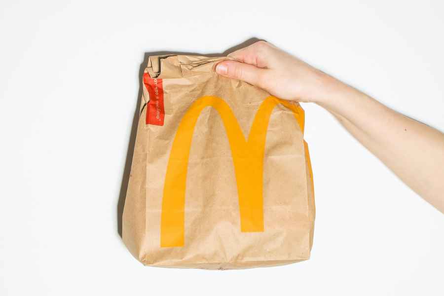 hand holding McDonalds bag