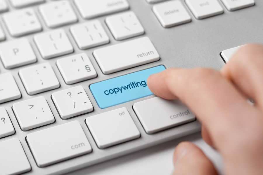 An email copywriter pressing a "Copywriting" key on their laptop. 