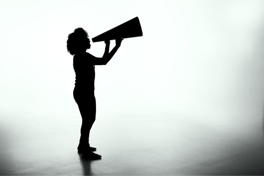 silhouette of a woman using a loudspeaker