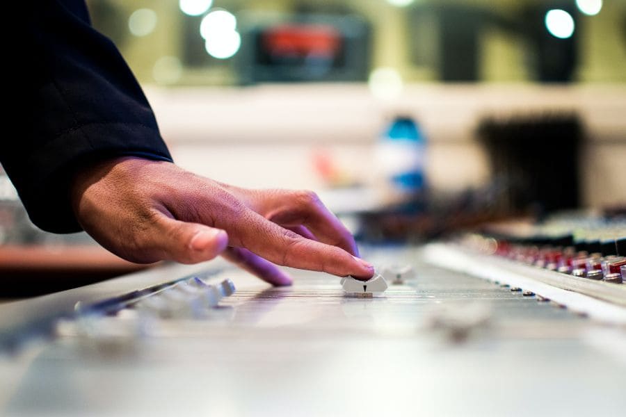 a hand moving the slider on a music production instrument