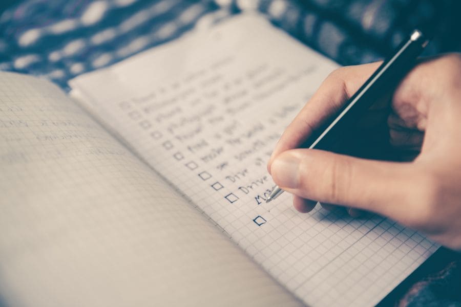 a hand writing a checklist