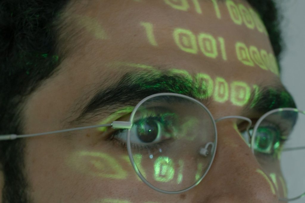 a man's forehead with green numbers projected on it