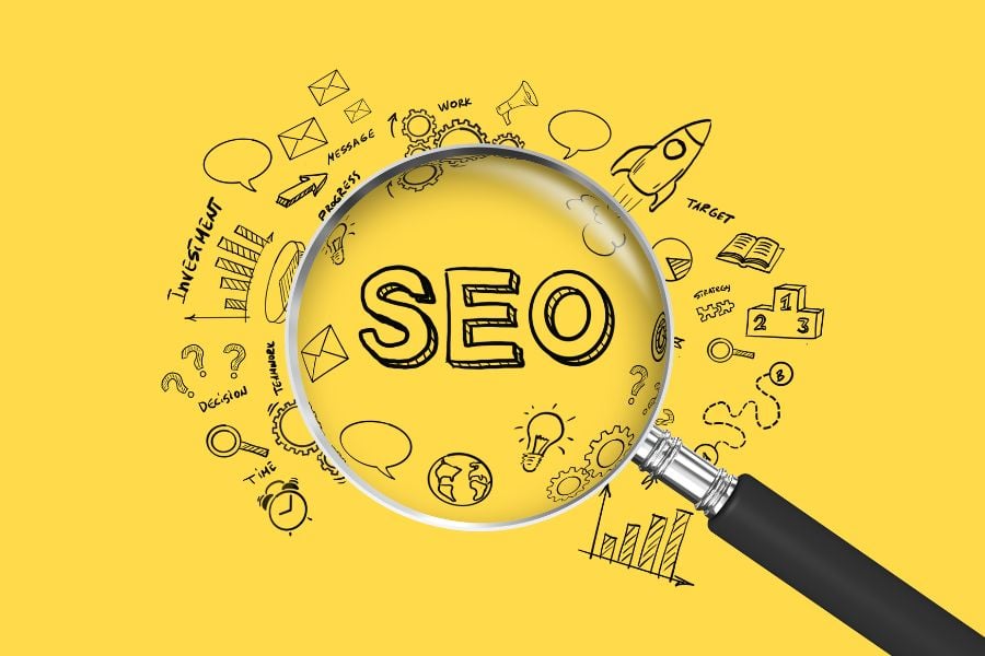 Magnifier highlighting SEO on a yellow background.