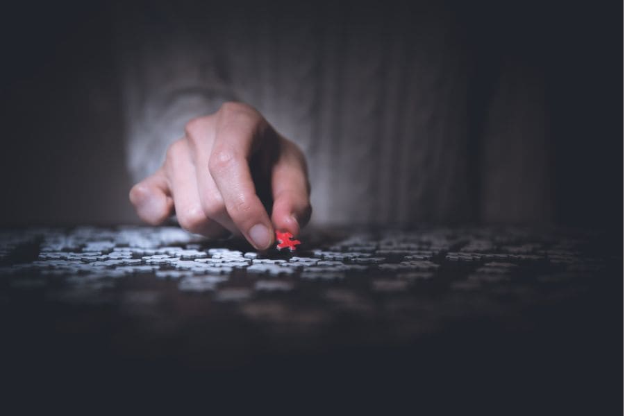 a hand putting down a red puzzle piece