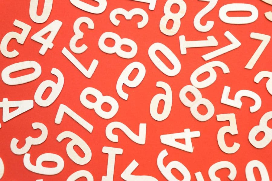paper cut numbers scrambled on an orange background