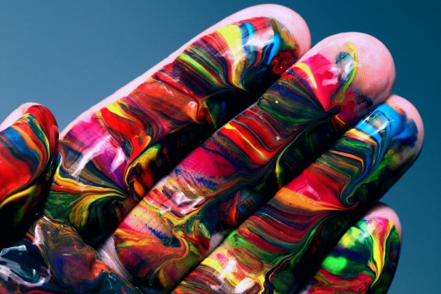 a hand with multicolored paint on it