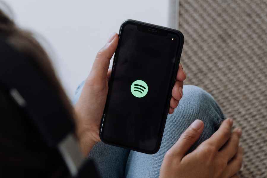 person holding laptop with spotify logo