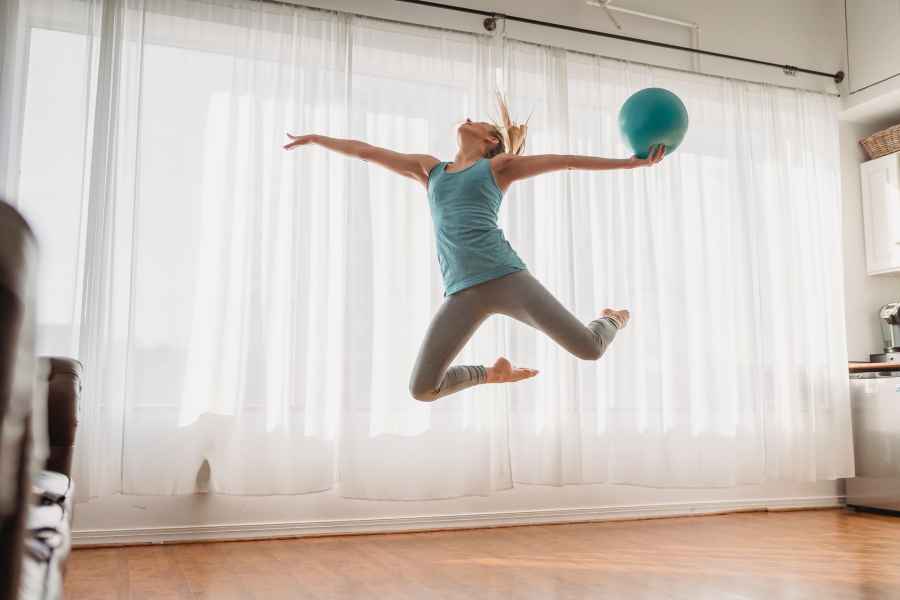 woman jumping with ball in hand