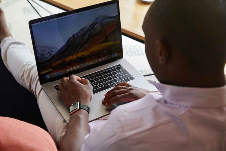 man using a laptop with mountain screensaver