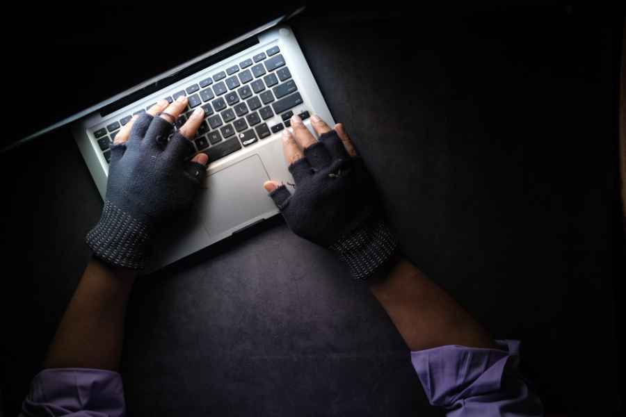 gloved hands using a laptop