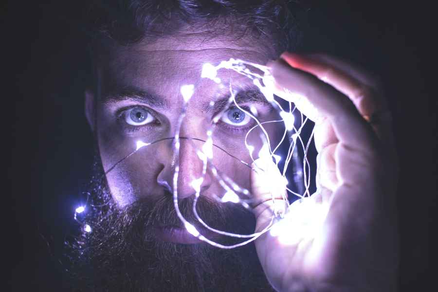 man holding lights in front of wide eyes