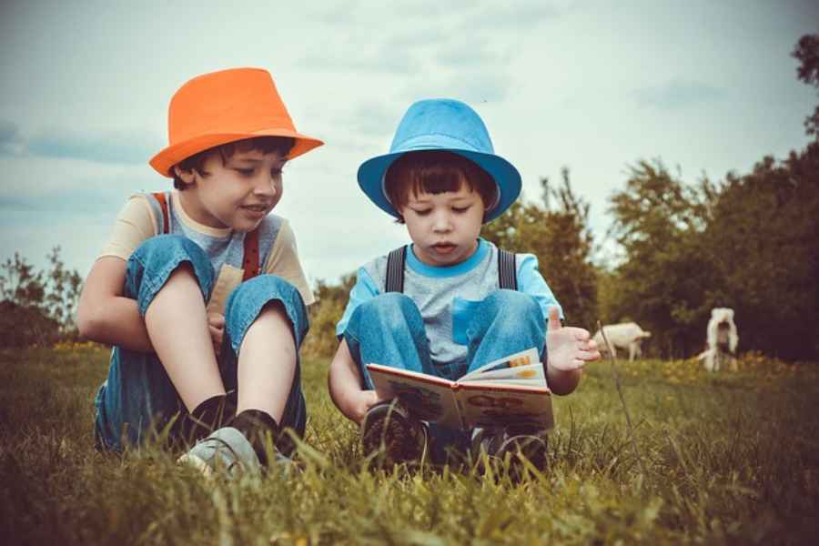 little boys in bowler hats reading picture book