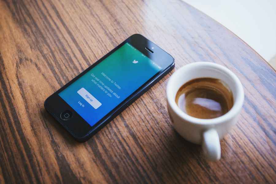 coffee cup next to blue twitter login screen